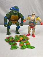 Full lot showing Leonardo figure, Super Cyborg figure, and two TMNT window hangers on tabletop.