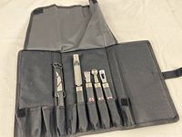 Five bar tools in canvas storage case, showing the full set and storage layout.