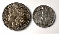 Obverse view of the 1879 Morgan silver dollar and the 1942D Standing Liberty half dollar showing Liberty's profile and standing figure.