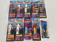 Photo of 10 Pez truck candy and dispenser sets, nine sealed on blister cards and one in plastic wrapper