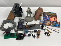 Full lot overview showing figures, vehicle parts, weapons, and booklet alongside pieces spread on white background