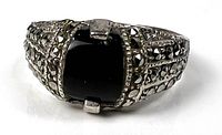 Front view of sterling silver ring with black rectangular marcalcite stone and marcasite accents on band.