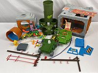 Overview of Teenage Mutant Ninja Turtles playset accessories including vehicles, base structure, pipes, fences, and small figures.