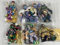Photo of seven Teenage Mutant Ninja Turtles action figures sealed in plastic bags, showing full lot contents.