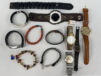 Full spread of four wristwatches and a variety of leather and beaded bracelets and wristbands including woven and braided styles