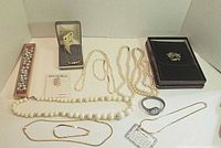 Lot overview showing pearl necklaces, gold tone jewelry, Timex watch, and boxed jewelry set