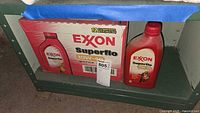 Photo of a red Exxon Superflo 10W-40 motor oil bottle alongside a partially visible box of 12 bottles.