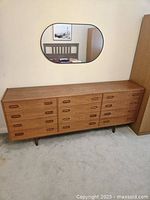Front view of Dyrlund teak dresser with twelve drawers and recessed pulls
