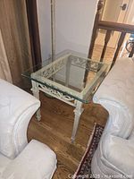 Full view of glass top side table between sofas