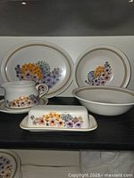 Full set on shelf showing platter, plate, bowl, creamer with saucer, butter dish