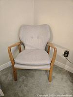 Front view of accent chair showing overall design and natural wood frame