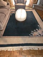 Full view of rug in room showing overall design and fringed edge