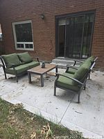 Full patio set showing loveseat, two chairs, coffee table and cushions
