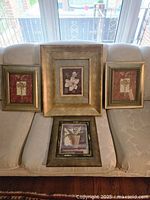 All four framed prints displayed on couch for scale