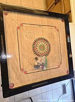 Full view of wooden carrom board with pieces bag