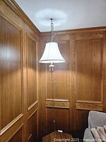 Full view of swag lamp hanging in corner, showing entire chain, cord, and shade
