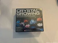 Front of the sealed 4M Crystal Growing Experimental Kit box showing the product name, age recommendation, and colorful crystal examples.