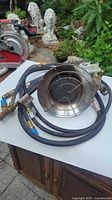 Photo of the propane tank heater unit showing the front of the heater, attached hoses and brass fittings.