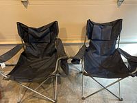 Two navy blue collapsible camp chairs side by side showing overall shape and color
