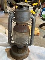 Full view of the vintage Beacon barn railroad lantern showing metal frame, glass globe, and handle.