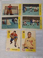 Six 1958-59 Parkhurst hockey cards featuring Montreal Canadiens players and game scenes arranged on white surface. Cards have yellow sidebars with player names and numbered.
