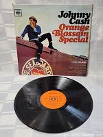 Photo of Johnny Cash Orange Blossom Special vinyl record on white surface showing the vinyl disc and orange label