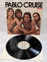 Front view of Pablo Cruise Lifeline vinyl LP record partially removed from cover showing band members on cover and record label.