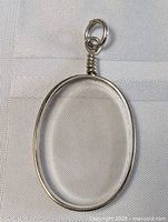 Clear oval-shaped crystal pendant set in sterling silver with a simple wire wrapped bail, showing the front view.