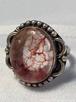 Front view showing the oval crimson cracked pattern stone and decorative beaded sterling silver setting.