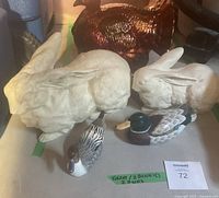 Photo showing 2 white ceramic bunnies, 2 small glass ducks, and large ceramic turkey figurine in background