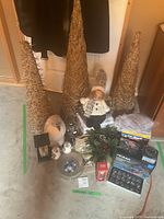 Wide angle shot of all Christmas decorations including trees, figurines, lantern, and boxed items on the floor