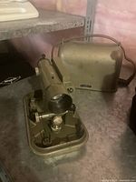 Close-up of the C.L. Berger & Sons survey instrument and its carrying case, showing the instrument's metal body and viewing scope.