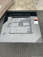 Top view of black tempered glass tabletop with removable square burner cover in center