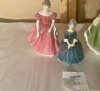 Arranged trio of porcelain figurines with visible colors and facial details.