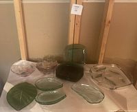 Photo of all 10 vintage glass dishes and bowls showing colors and shapes including floral, leaf, and textured designs.