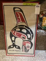 Full frontal view of framed artwork showing the stylized killer whale design in black and red on linen, with red frame.