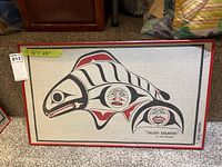 Framed artwork titled "Salish Salmon" by Joe Becker on linen fabric with red wooden frame, showing overall view.
