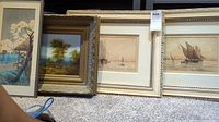 Four framed artworks grouped on floor: Japanese print, pastoral oil painting, two sailboat prints