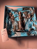 Candelabra nestled in blue and black tissue paper inside box with handwritten tag stating height and lot info