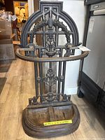 Front view of ornate cast iron umbrella stand showing overall design