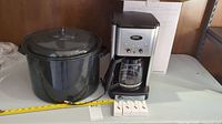 Cuisinart coffee machine in original box next to large enamel pot and four boxed collapsible metal straws.