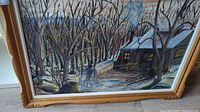 Framed oil painting showing winter or late autumn landscape with bare trees, a cabin, and pathway in muted earth and blue tones.