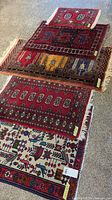 Five small rugs laid out on carpet floor, stacked diagonally showing patterns and fringe