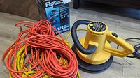 WEN Model 7010 waxer on floor next to orange and yellow extension cords and Flotec utility pump box.