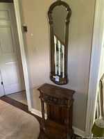 Mirror mounted above matching wooden hallway stand