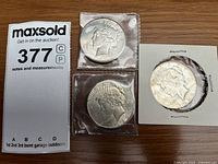 Obverse sides of three Peace Dollars in holders