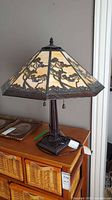 Full view of slag glass table lamp on dresser