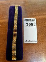 Full view of gold bracelet on display pad