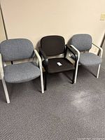 Front view of three upholstered office arm chairs side by side
