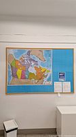 Front view of full corkboard on wall with map and notices